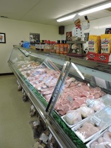 Indoor view of butcher shop, hot sauces, raw meat